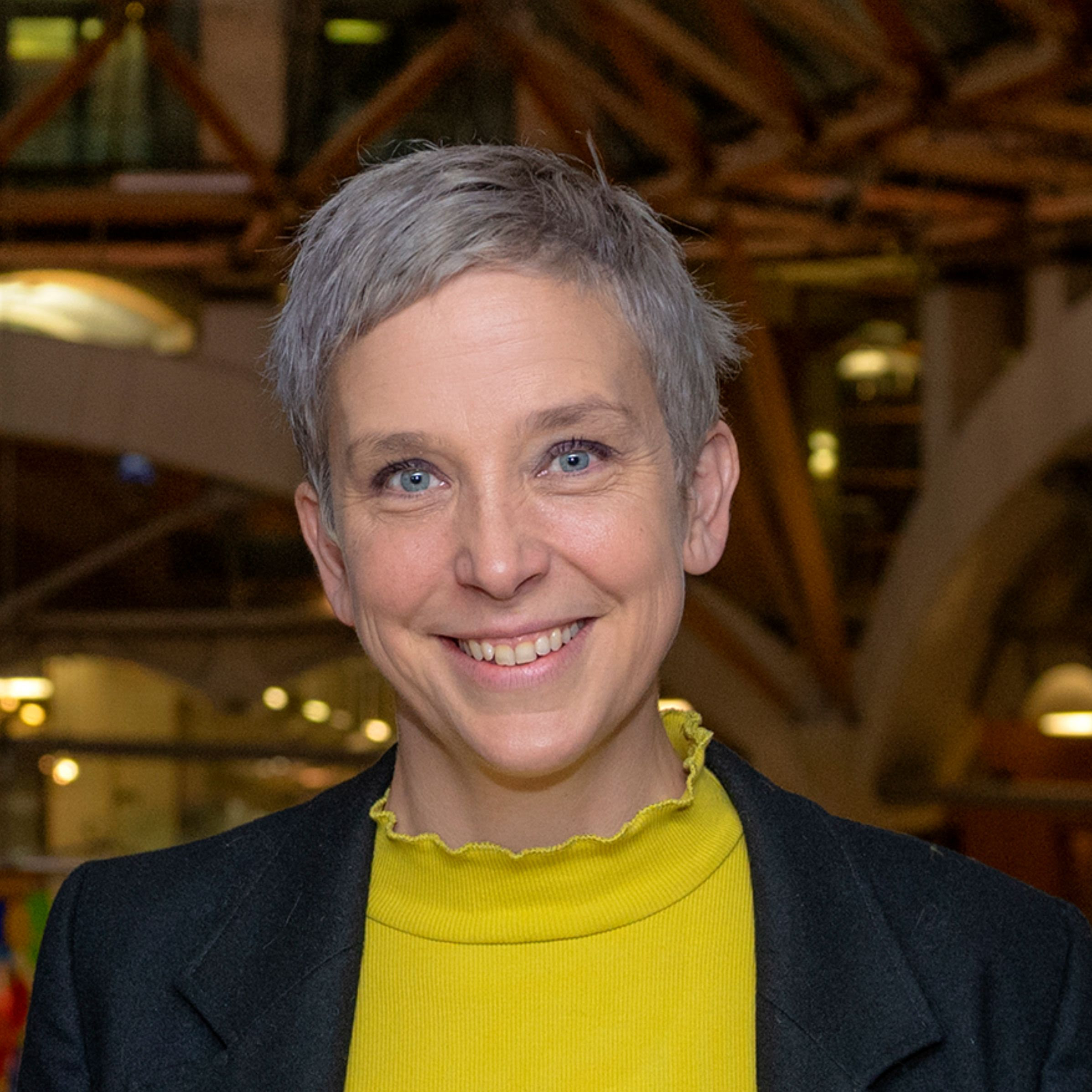 Headshot of Professor Tamsin Edwards, standing inside Parliament's Portcullis House